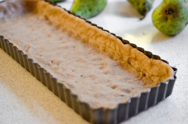 Prsty vtlačte těsto do formy a předpečte jej.