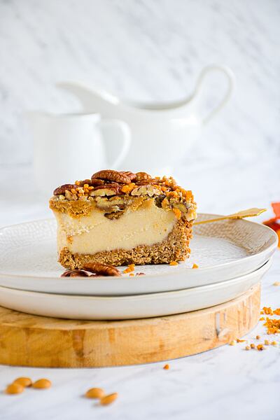 Pekanový cheesecake ozdobte karamelovou čokoládou a ořechy. Chutě k sobě neuvěřitelně dobře ladí.