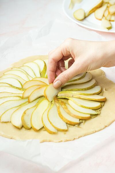 Těsto potřeme pistáciovým máslem a poklademe plátky hrušek. Okraje necháme volné.