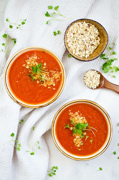 Hotovou rajčatovou polévku můžete ozdobit oříškovou posypkou a zelenými klíčky.