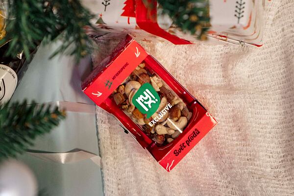 Dárkové balení ořechové směsi MYX Exclusive pod vánočním stromečkem.